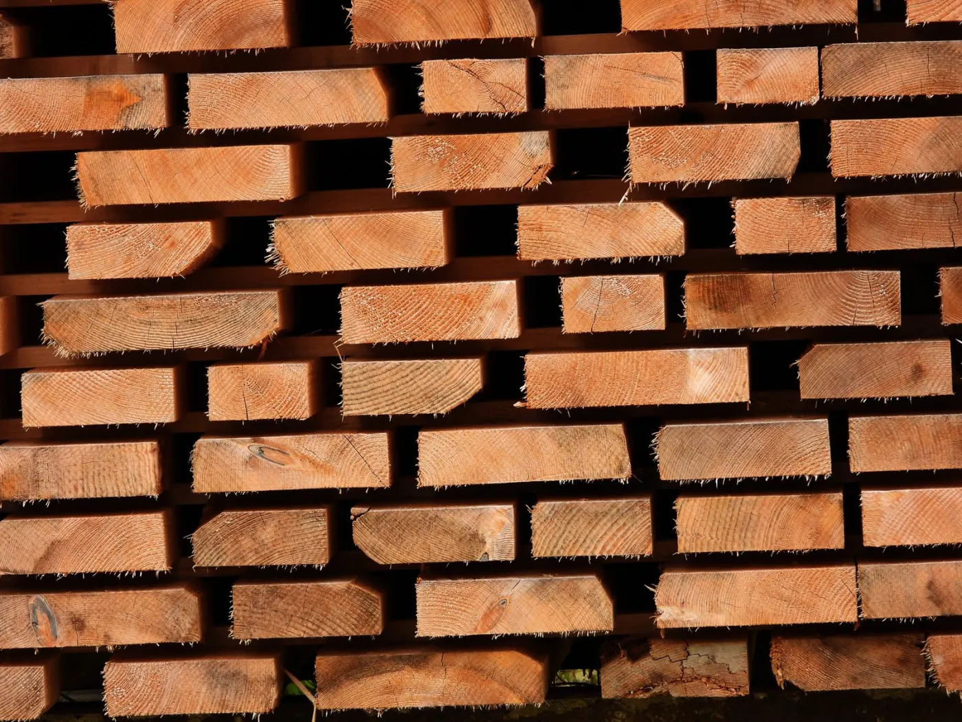 Naukladané stavebné rezivo — hranoly a dosky pripravené na expedíciu